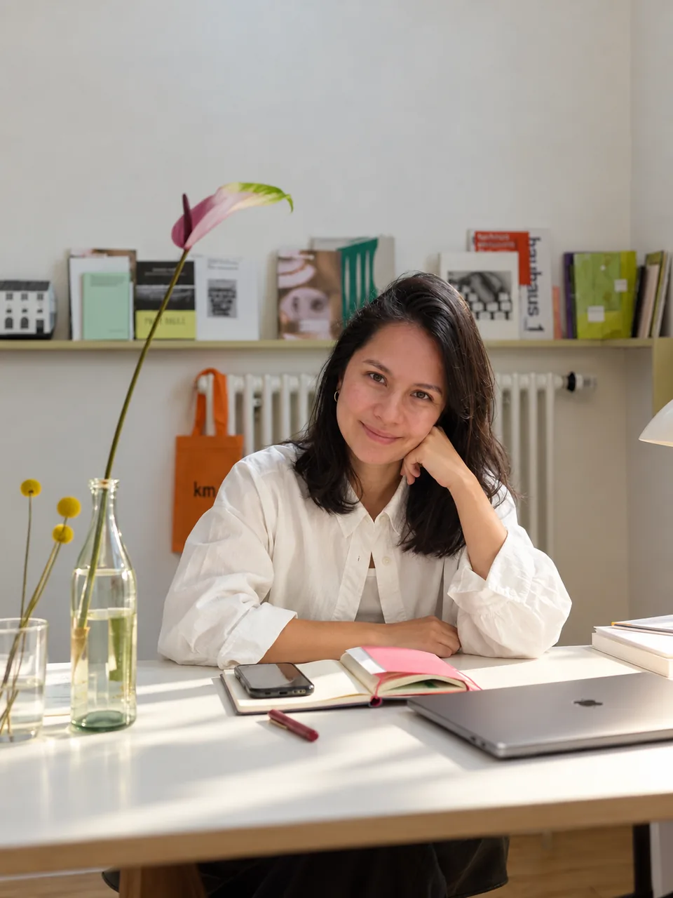 Justine Herlin, Fractional Founding Marketer, smiling at her desk with a notebook and laptop